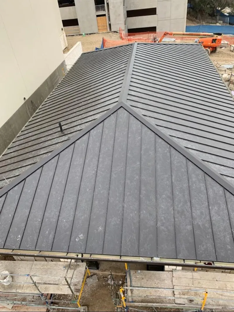 Commercial metal roof construction with crane equipment in Hamden